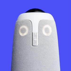 Die Meeting Owl 3 Konferenzkamera in Nahaufnahme vor blauem Hintergrund, entwickelt für 360-Grad-Video- und Audioübertragung in hybriden Meetings und Konferenzräumen.